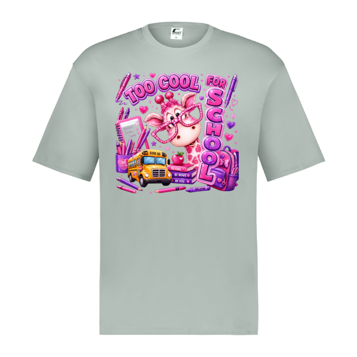 A silver color short-sleeve crewneck t-shirt featuring a colorful graphic print on the front. The graphic depicts a pink cartoon pig wearing glasses next to a yellow school bus, surrounded by pink pens, hearts, and the text 'TOO COOL FOR SCHOOL'.