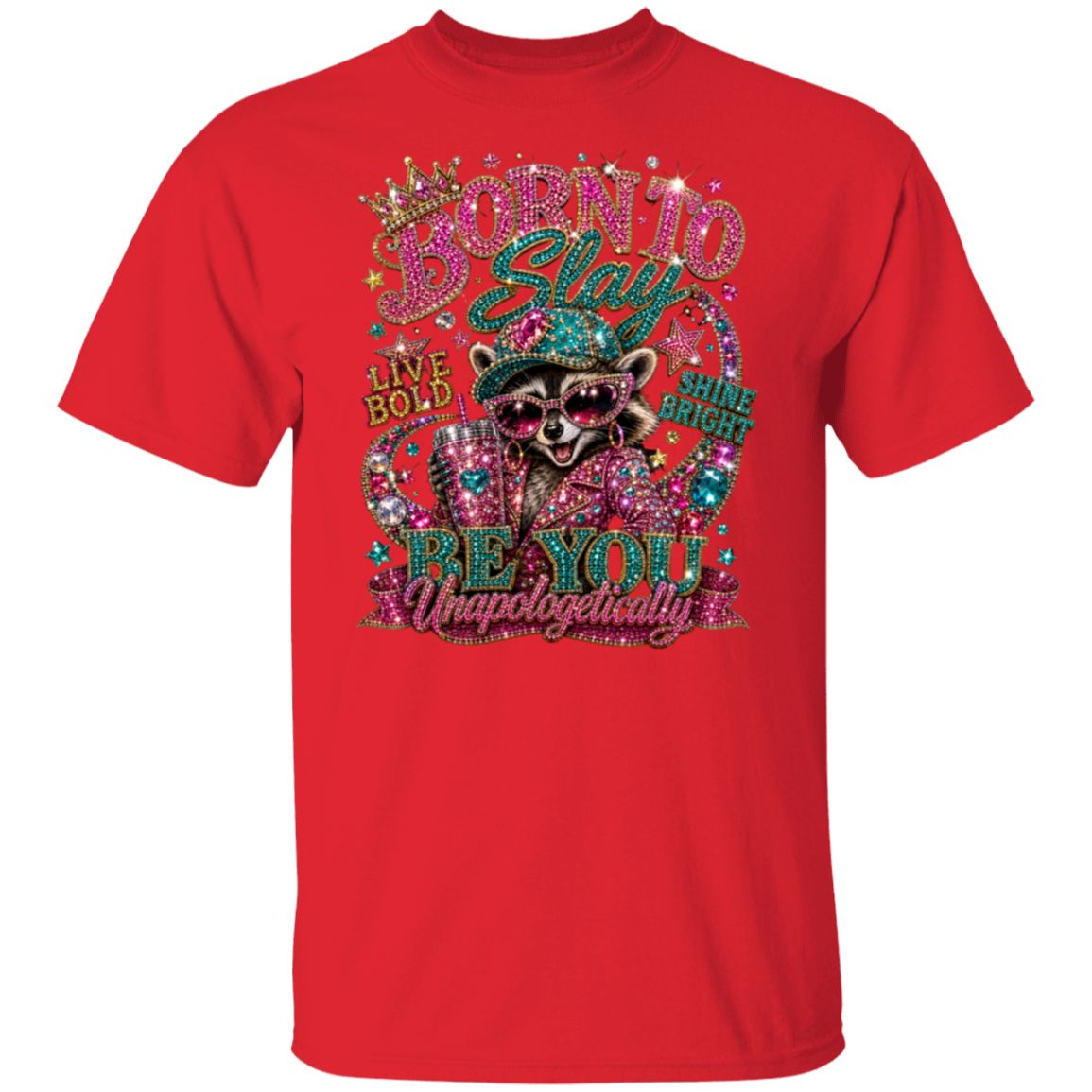 A red short-sleeve crewneck t-shirt featuring a large, colorful graphic on the front. The graphic depicts a raccoon wearing a green bowler hat and sunglasses, surrounded by glittery rhinestone-style text that reads 'BORN TO Stay LIVE BOLD BE YOU Unapologetically' with 'GIRLS LIKE YOU' on the right.