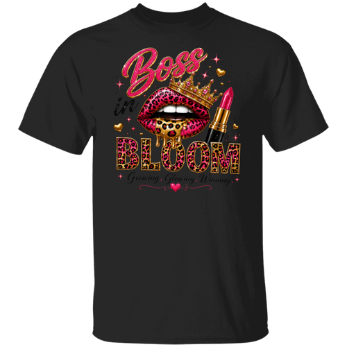 A black short-sleeve crewneck t-shirt featuring a vibrant graphic print on the front. The design includes the words 'Boss is BLOOM' in pink and leopard-print lettering, accompanied by a pair of leopard-print lips wearing a gold crown, a pink lipstick tube, and small gold hearts.