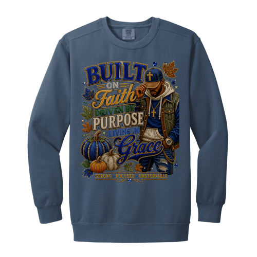 A blue jean color crewneck sweatshirt featuring a large, detailed graphic print on the front. The graphic depicts a man wearing a cap and gold chain next to pumpkins and autumn leaves, surrounded by text that reads 'BUILT ON Faith, LIVING BY PURPOSE, GIVING Grace'