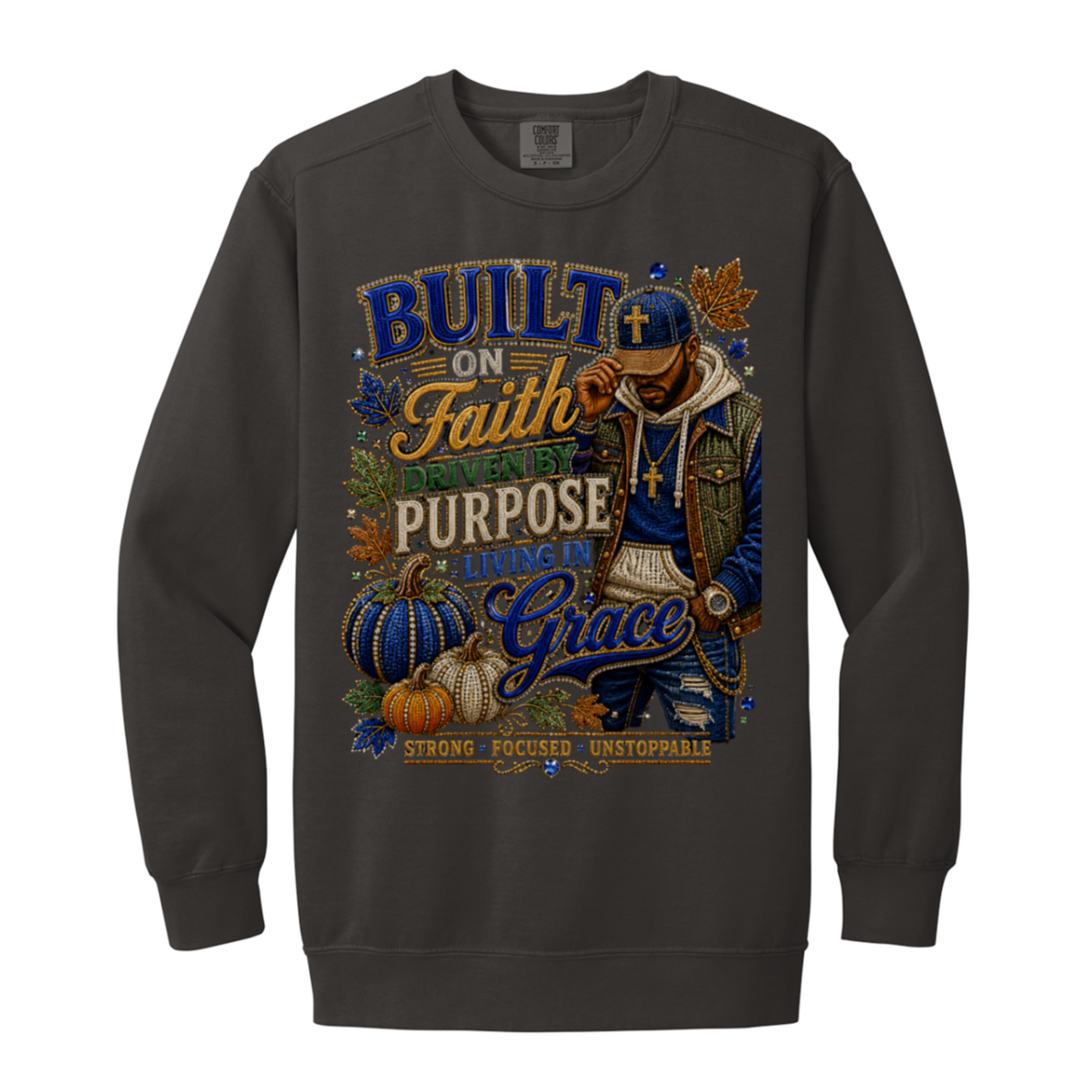 A pepper color crewneck sweatshirt featuring a large, detailed graphic print on the front. The graphic displays a man in a blue cap and jacket, pumpkins, autumn leaves, and text reading 'BUILT ON Faith PURPOSE LIVING IN Grace' with 'STRONG FOCUSED UNSTOPPABLE'.
