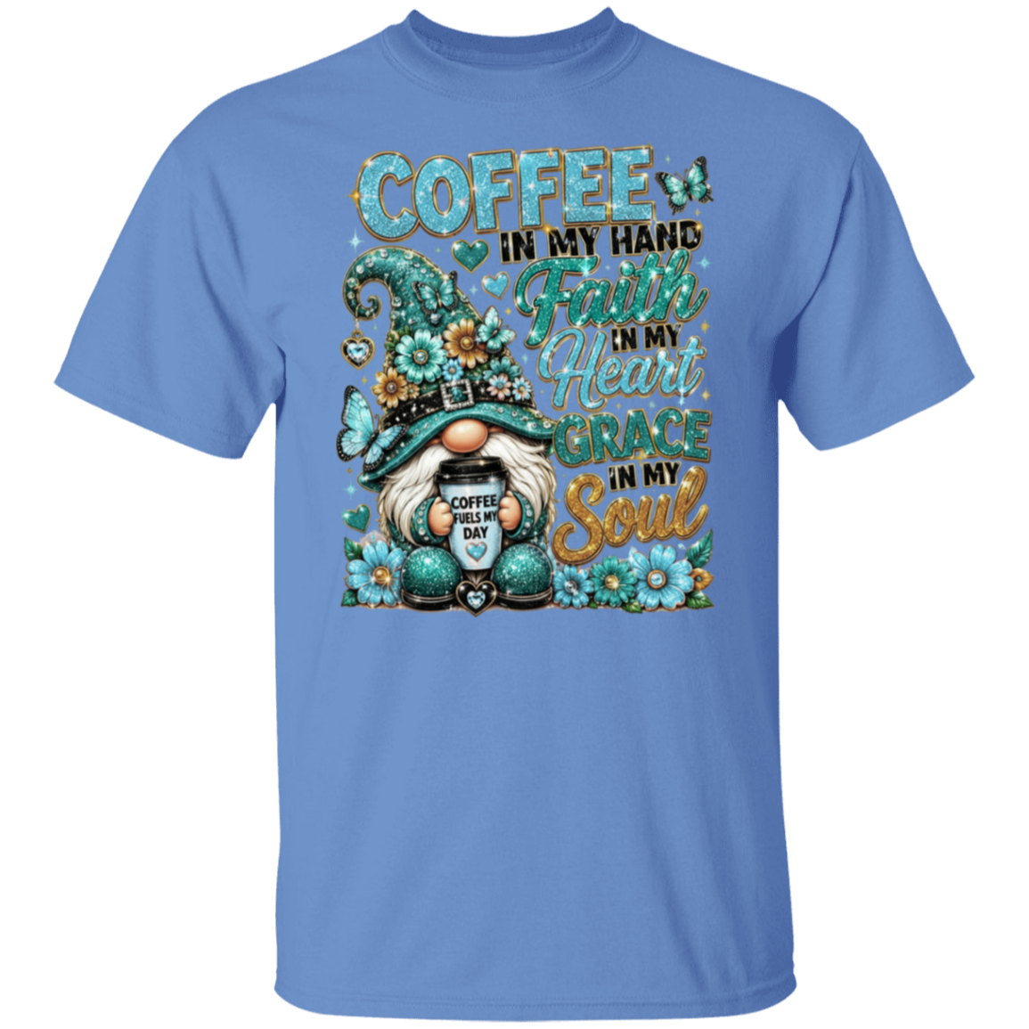 A Carolina blue short-sleeve crewneck t-shirt featuring a large graphic print on the front. The graphic depicts a gnome wearing a green hat and holding a coffee mug, surrounded by flowers and butterflies, with the text 'COFFEE IN MY HAND Faith IN My Heart Courage IN My Soul'.