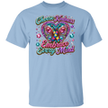 A light blue short-sleeve crewneck t-shirt featuring a colorful graphic on the front. The graphic displays a glittery butterfly with a teal and orange awareness ribbon inside its wings, surrounded by sparkling gem details and the text 'Choose Kindness Embrace Every Mind' in a stylized, multi-colored font.