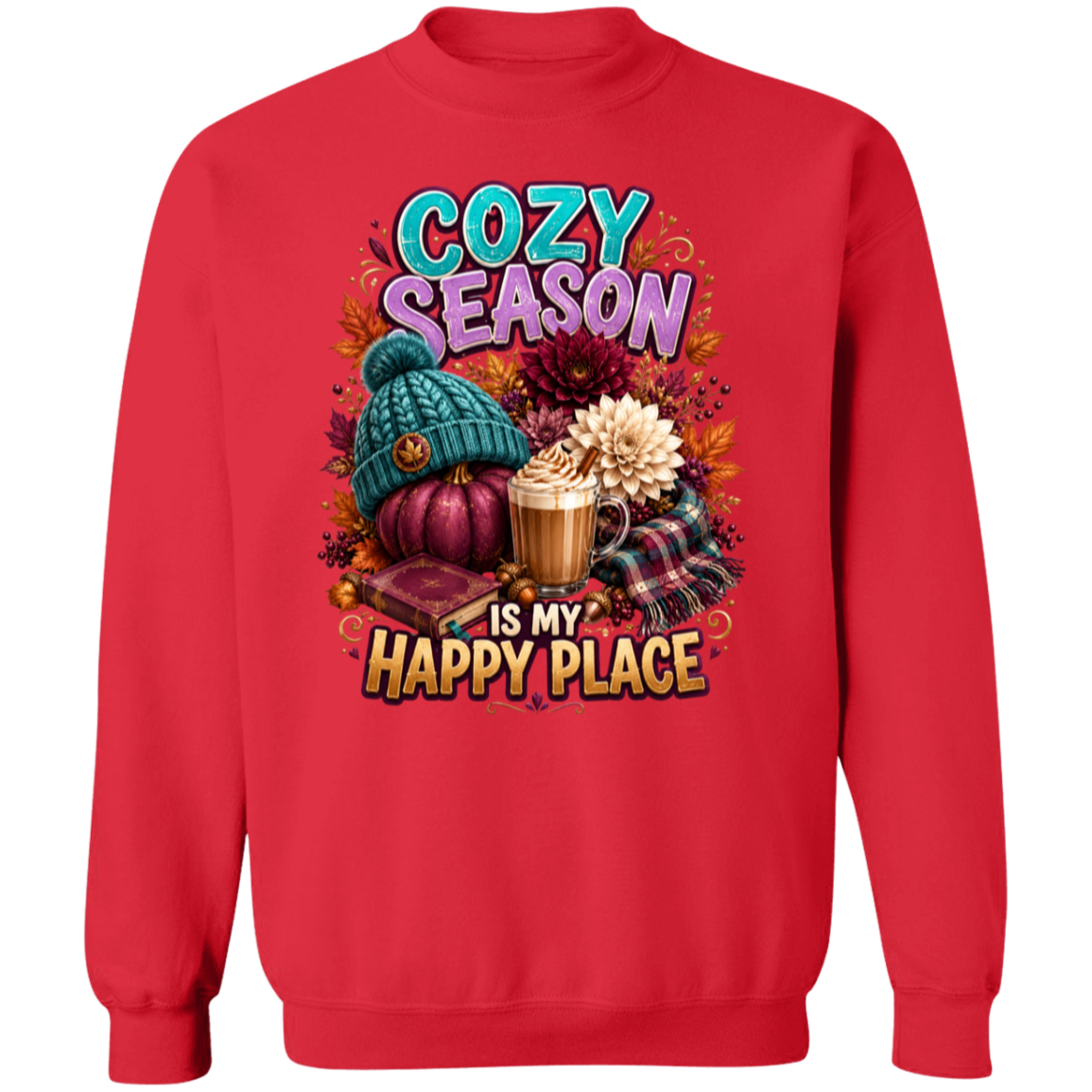 A red crewneck sweatshirt featuring a colorful graphic print with autumn and cozy elements, including a teal knit hat, a pumpkin, a hot cocoa mug, and the text 'COZY SEASON IS MY HAPPY PLACE'.