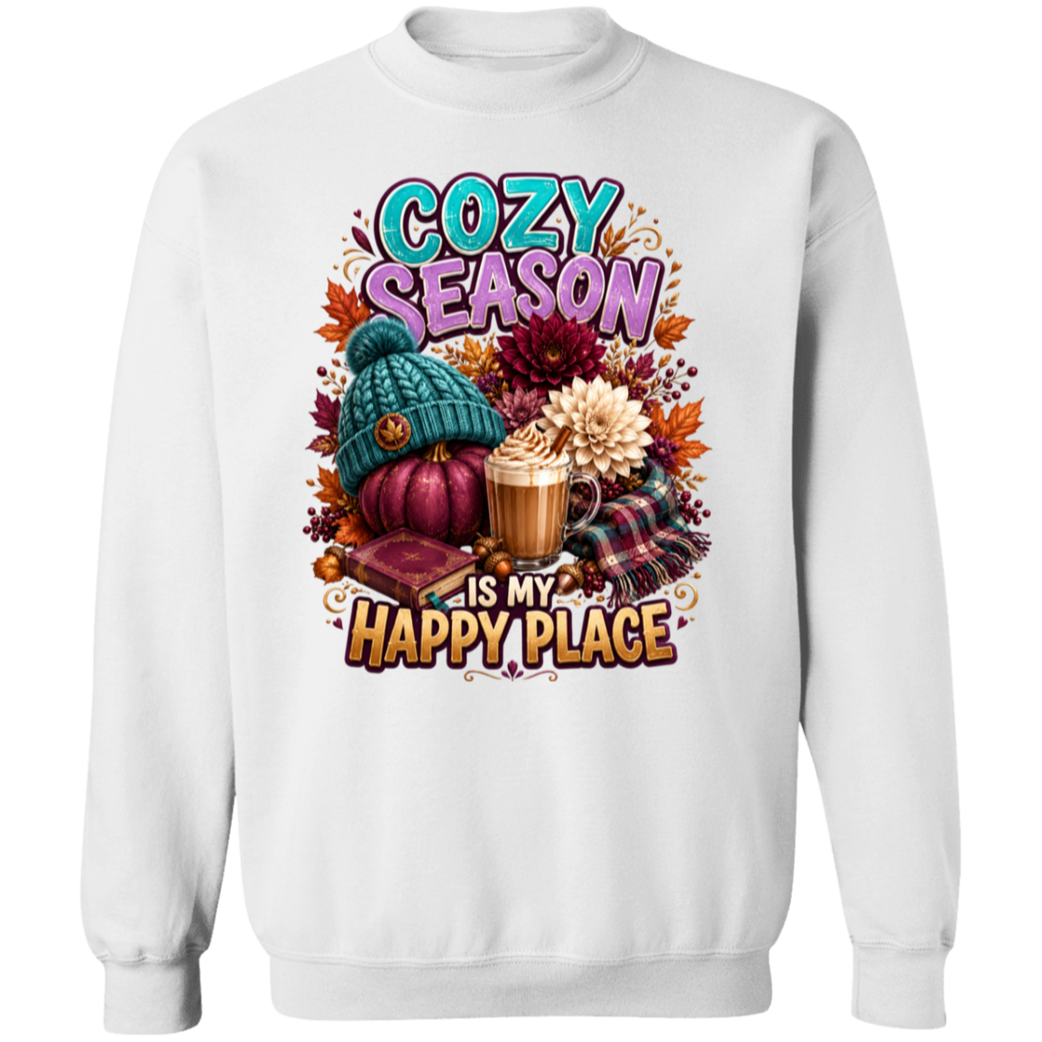 A white crewneck sweatshirt featuring a colorful autumn-themed graphic print with the text 'COZY SEASON IS MY HAPPY PLACE' and illustrations of a pumpkin, knit hat, coffee mug, flowers, and plaid fabric.