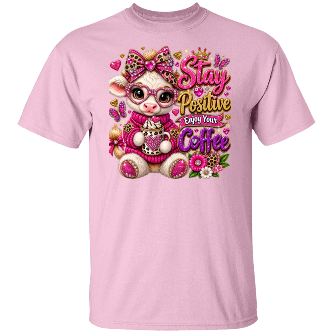 A light pink short-sleeve crewneck t-shirt featuring a colorful graphic of a cute cartoon baby goat wearing pink glasses and a pink sweater, surrounded by hearts, flowers, and the text 'Stay Positive Enjoy Your Coffee'.
