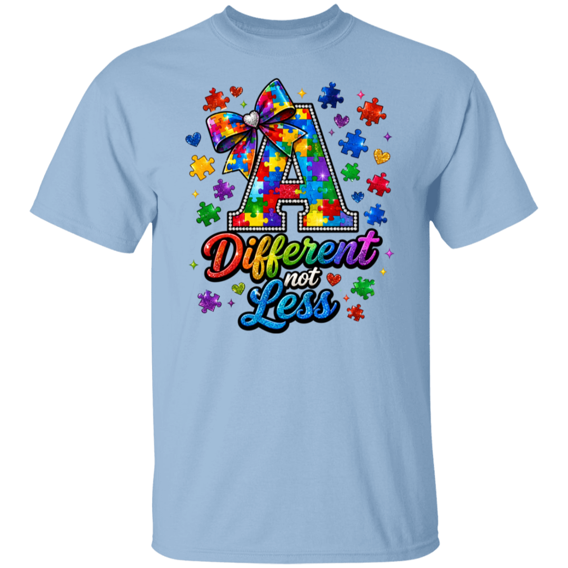 A light blue short-sleeve crewneck t-shirt featuring a colorful graphic on the chest. The graphic displays a large letter 'A' filled with a rainbow puzzle-piece pattern and a matching bow, surrounded by puzzle pieces and hearts, with the text 'Different not Less' written below in a rainbow gradient.