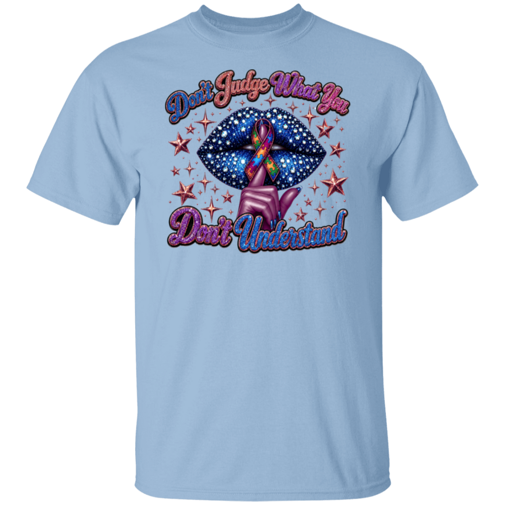 A light blue short-sleeve crewneck t-shirt featuring a graphic design on the front. The graphic shows a pink hand holding a blue starry lips-shaped object with a rainbow awareness ribbon inside, surrounded by red stars, with the text 'Don't Judge What You Don't Understand!' in pink and purple cursive.