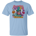 A light blue short-sleeve crewneck t-shirt featuring a colorful graphic of a cute cartoon koala wearing a teal knit hat and scarf, holding a mug with 'COZY' written inside. The graphic is surrounded by glittery text reading 'Sweater VIBES COZY SEASON' and autumn-themed decorations, shown against a plain white background.