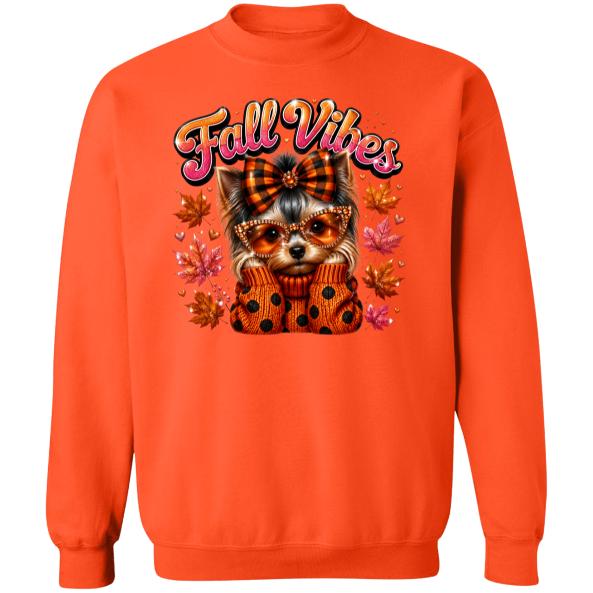 An orange crewneck sweatshirt featuring a graphic of a small dog wearing a plaid bow and polka-dot sweater, surrounded by autumn leaves and the text 'Fall Vibes' in a pink and yellow gradient font.