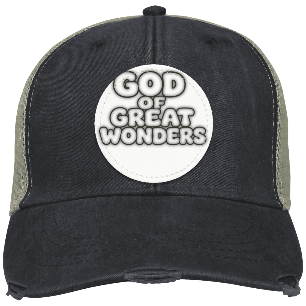 A distressed trucker hat with a black front panel and brim, olive green mesh side panels, and a circular white patch on the front reading 'GOD OF GREAT WONDERS'.