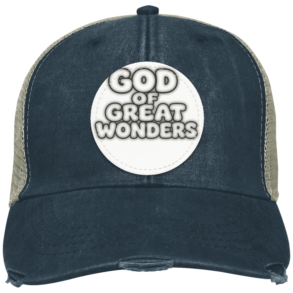 A distressed trucker hat with a black color front panel and brim, beige mesh side panels, and a circular white patch on the front reading 'GOD OF GREAT WONDERS'.