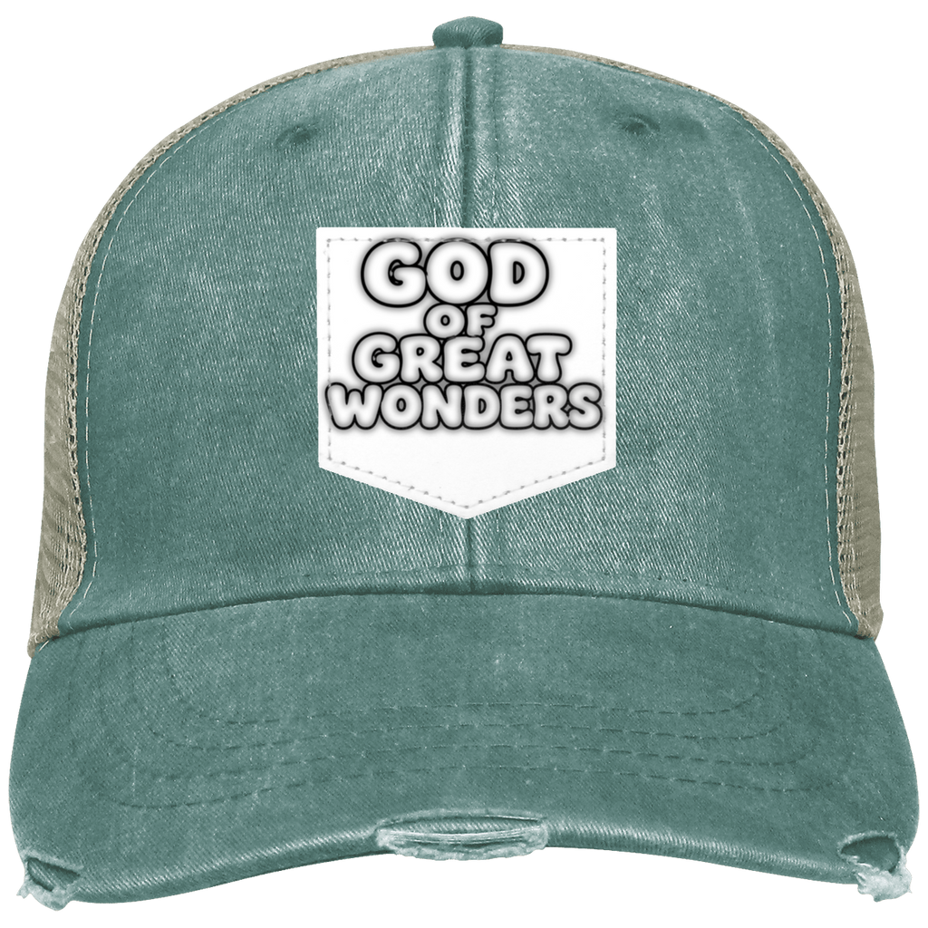 A distressed trucker hat in washed teal green with beige mesh side panels and a white shield-shaped patch on the front that reads 'GOD OF GREAT WONDERS'.
