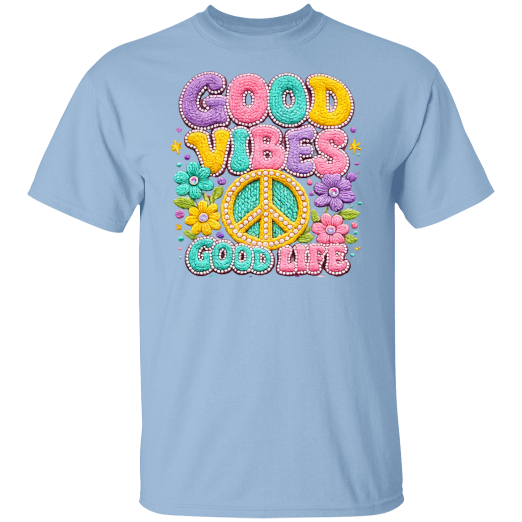 A light blue short-sleeve crewneck t-shirt featuring a colorful retro graphic on the chest with the text 'GOOD VIBES GOOD LIFE' in pastel bubble letters and a peace sign surrounded by flowers.