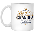 A white ceramic coffee mug with a printed 'Happy Birthday Grandpa Best Grandpa Ever' design in gold and navy blue text, shown on a plain white background.