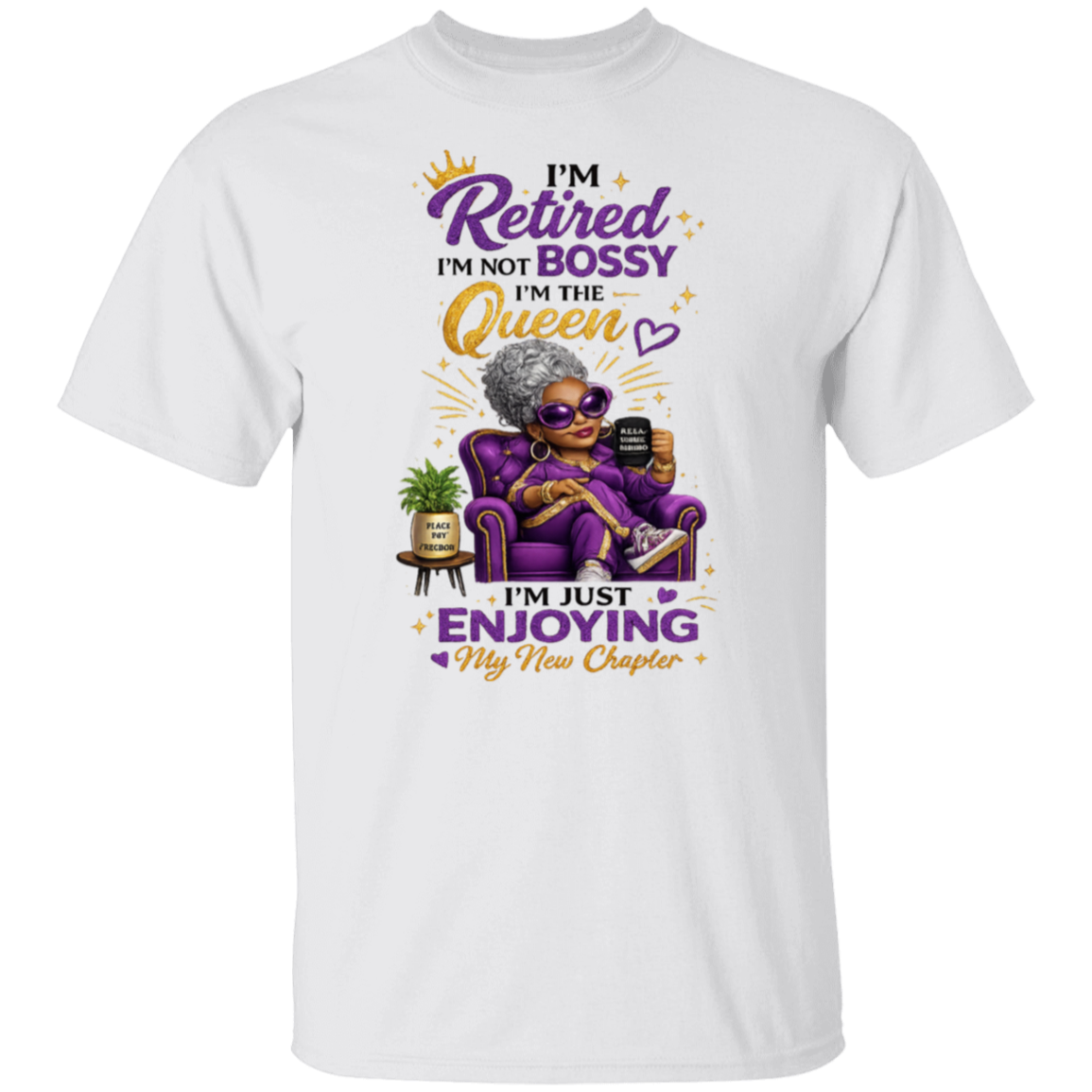 A white short-sleeve crewneck t-shirt featuring a colorful graphic of an elderly woman in a purple armchair with the text 'I'm Retired I'm NOT BOSSY I'm THE Queen I'm JUST ENJOYING My New Chapter' in purple and gold lettering.