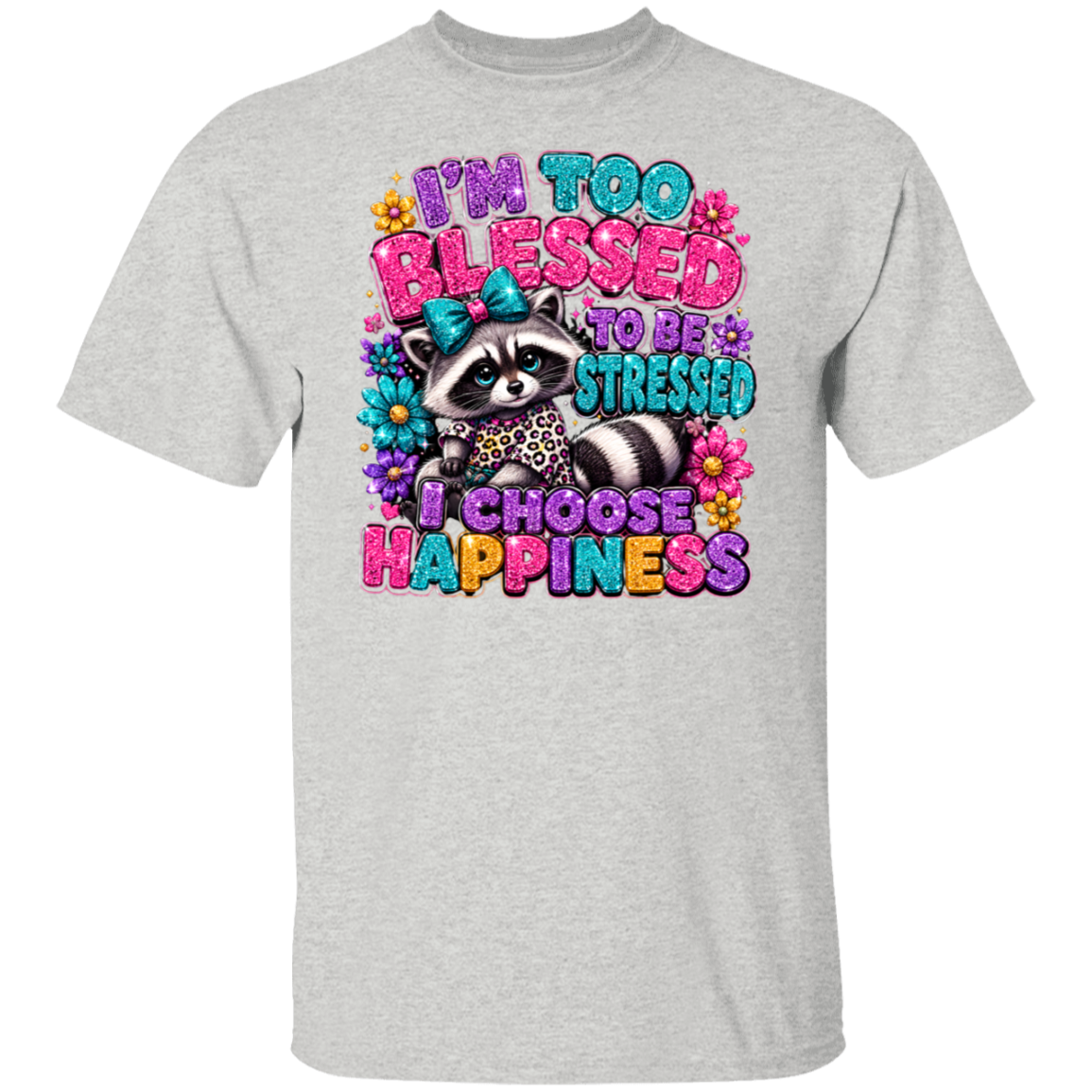 An ash color short-sleeve t-shirt with a colorful graphic print of a raccoon surrounded by flowers and the text 'I'M TOO BLESSED TO BE STRESSED I CHOOSE HAPPINESS' in vibrant, glittery lettering.