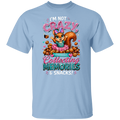 A light blue short-sleeve crewneck t-shirt featuring a colorful graphic of a cartoon squirrel surrounded by snacks, with the text 'I'M NOT CRAZY, Collecting MEMORIES & SNACKS!'.