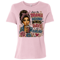 A light pink short-sleeve t-shirt with a colorful graphic print on the front. The graphic features an illustration of a woman with her hair in a messy bun, holding a drink, surrounded by flowers and the text 'Leave the DRAMA BEHIND The Best DAYS & Are AHEAD'.