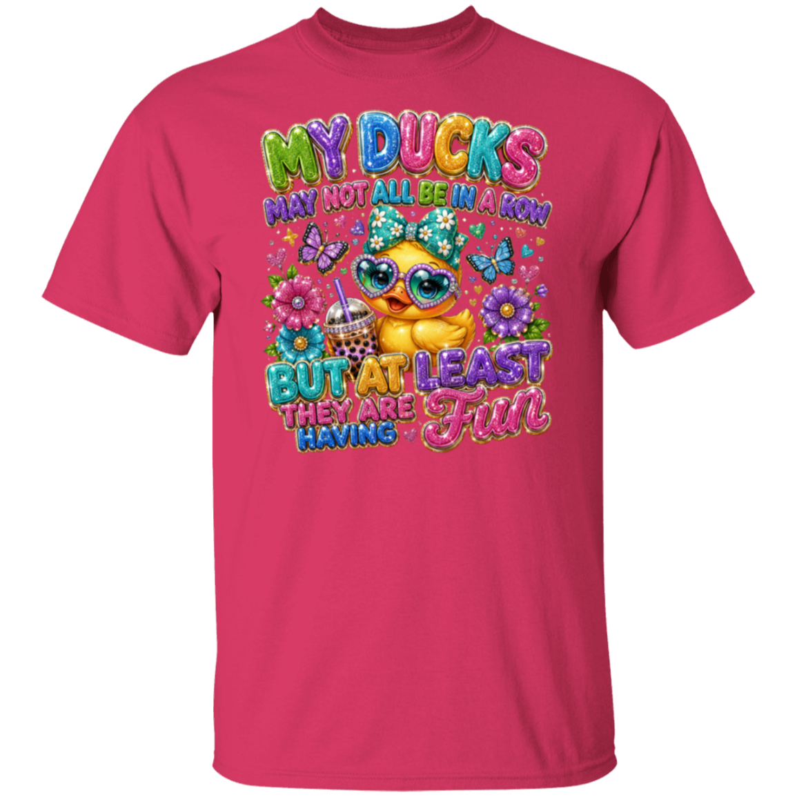 A heliconia color short-sleeve t-shirt with a colorful graphic print on the front. The graphic features a cute yellow duck wearing sunglasses, surrounded by flowers, butterflies, and the text 'MY DUCKS MAY NOT ALL BE IN A KIM BUT AT LEAST THEY ARE HAVING A FUN'.
