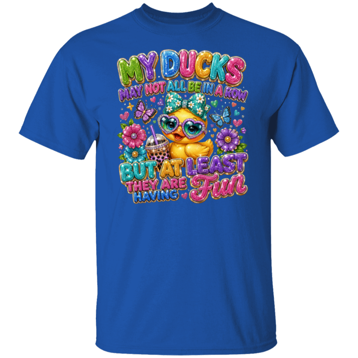 A royal blue short-sleeve t-shirt with a colorful graphic print featuring a cartoon duck, flowers, butterflies, and the text 'MY DUCKS MAY NOT ALL BE A KHON BUT AT LEAST THEY ARE HAVING FUN'.