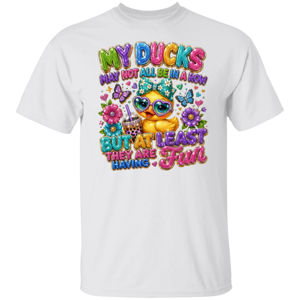 A white short-sleeve crewneck t-shirt featuring a colorful graphic print on the front. The graphic shows a cute cartoon duck wearing sunglasses and a party hat, surrounded by flowers, butterflies, and the text 'MY DUCKS MAY NOT ALL BE IN A ROW BUT AT LEAST THEY ARE HAVING Fun'.