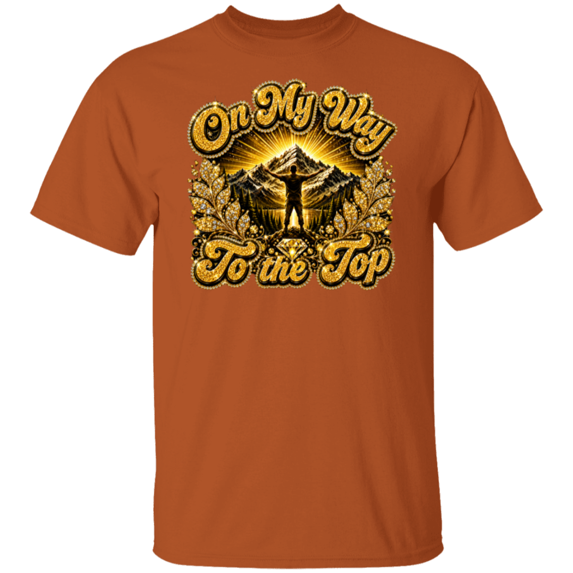 A Texas orange short-sleeve crewneck t-shirt featuring a large graphic print on the front with the text 'On My Way To the Top' in a gold glitter-style font, surrounding an illustration of a mountain peak and a silhouette of a person standing on top.
