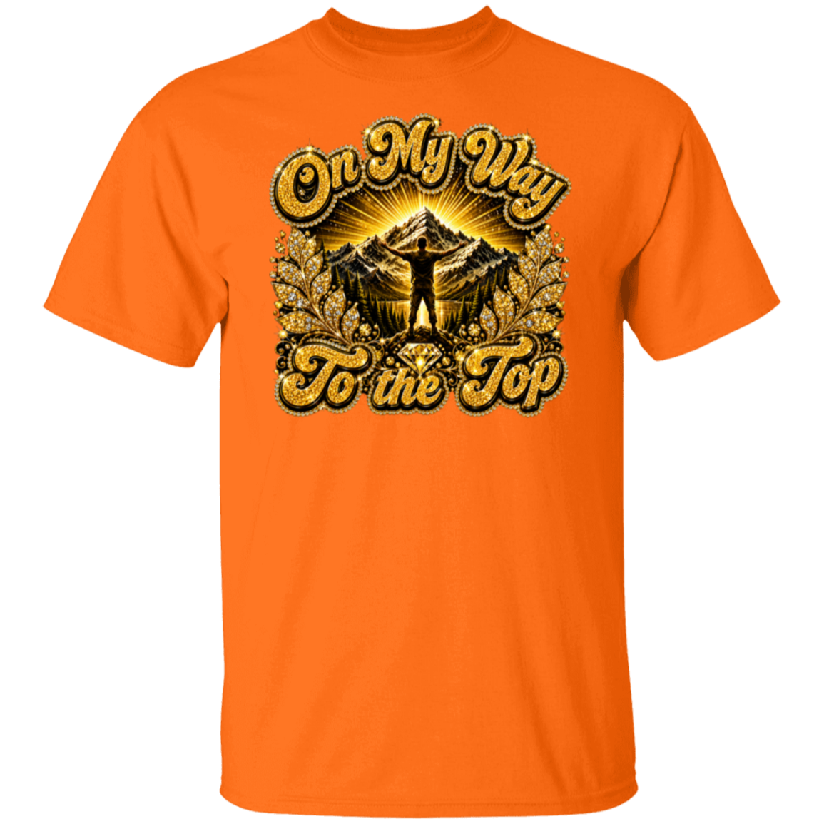 An orange short-sleeve crewneck t-shirt featuring a large graphic print on the front with the text 'On My Way To the Top' in a gold glitter-style font, surrounding an illustration of a mountain peak, sun rays, and a silhouetted figure standing on top.