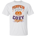 A white short-sleeve crewneck t-shirt featuring a festive graphic print on the front with the text 'PUMPKIN Vibes COZY Nights' in orange, purple, and gray, surrounding a jack-o'-lantern illustration.