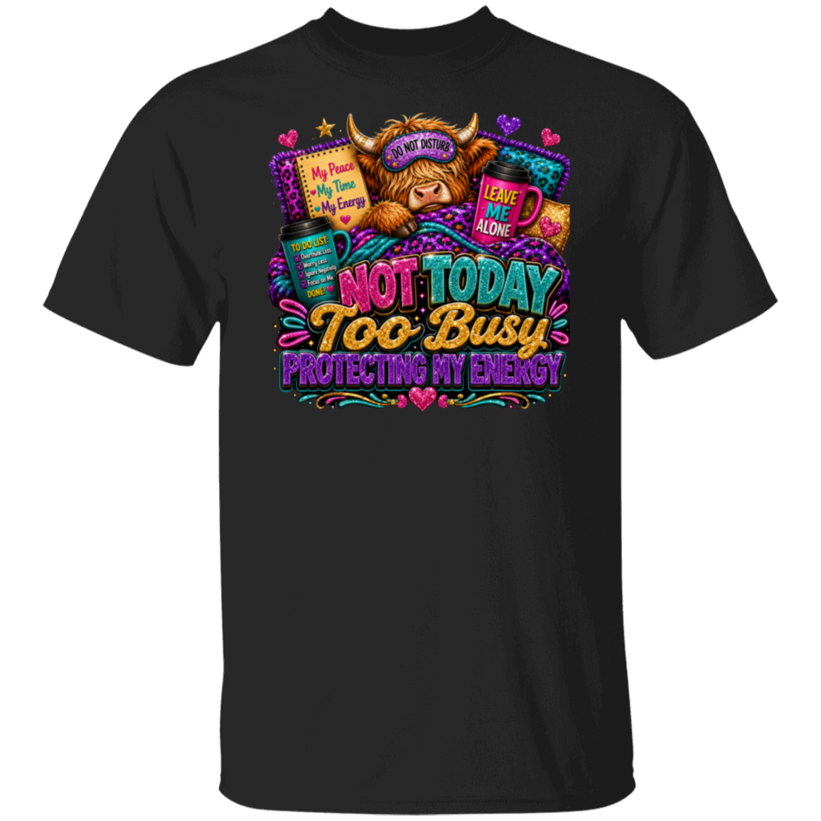 A black short-sleeve crewneck t-shirt featuring a colorful graphic print of a fluffy brown highland cow wearing a purple sleep mask with the text 'NOT TODAY TOO BUSY PROTECTING MY ENERGY' in vibrant stylized lettering.