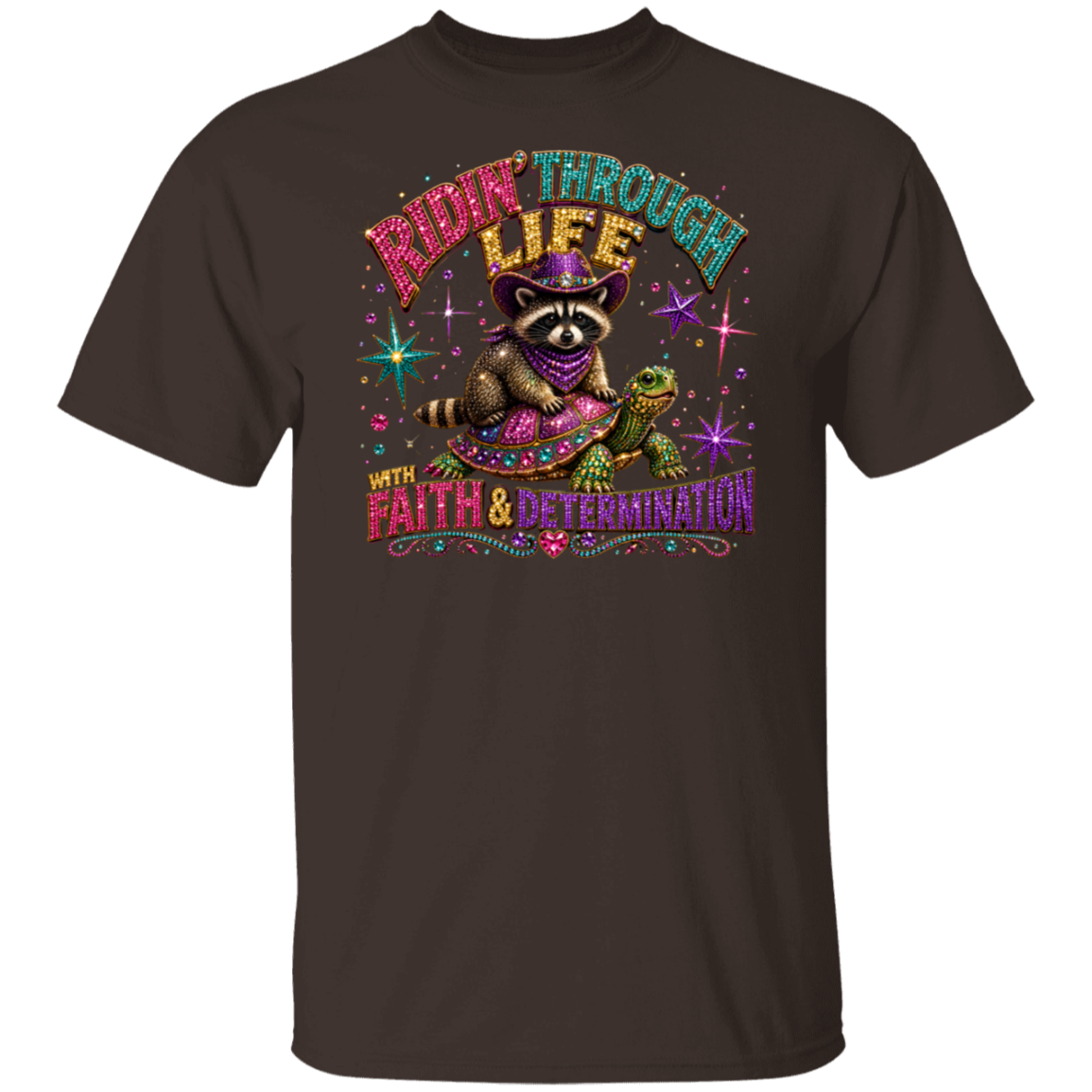A dark chocolate color short-sleeve crewneck t-shirt featuring a colorful graphic print of a raccoon riding a turtle on a starry background with the text 'RIDE THROUGH LIFE WITH FAITH & DETERMINATION'.