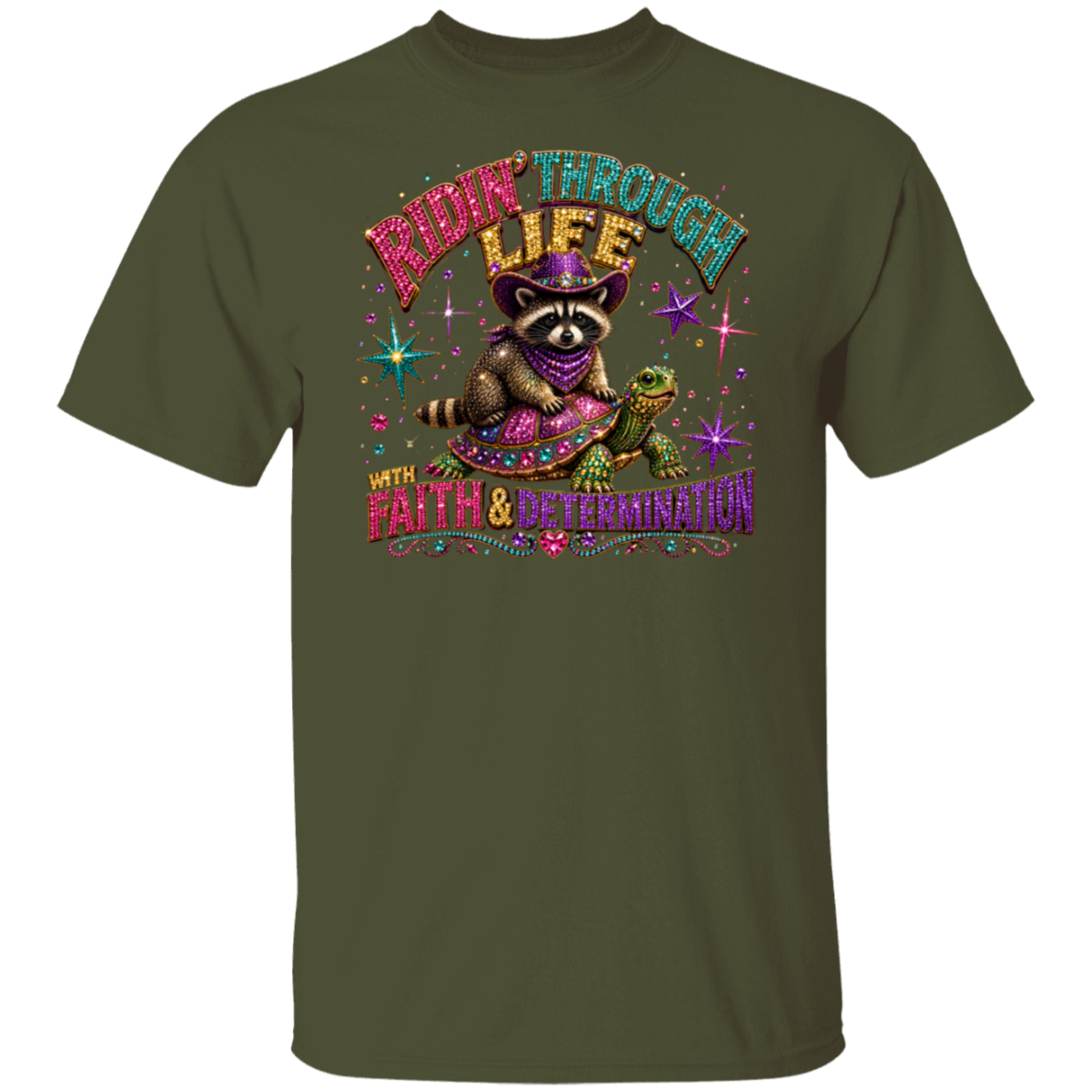 A military green short-sleeve t-shirt with a colorful graphic print on the front. The graphic features a raccoon wearing a purple bandana and sunglasses, sitting next to a green turtle, with the text 'RIDE THROUGH LIFE WITH FAITH & DETERMINATION' in a glittery, multi-colored font.