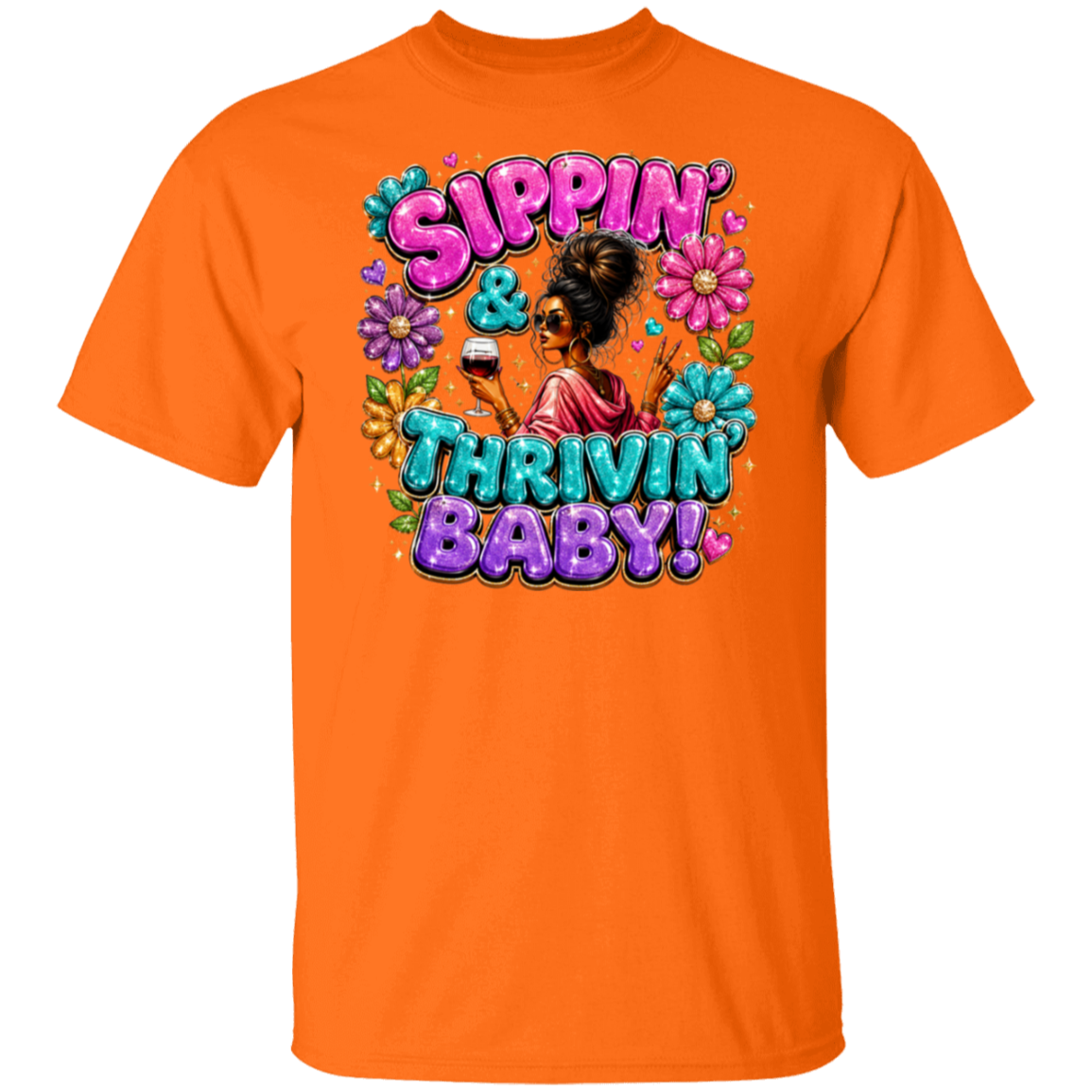 An orange color short-sleeve crewneck t-shirt featuring a colorful retro graphic on the front with the text 'Sippin' & Thrivin' Baby!' in pink, purple, and blue bubble lettering, surrounded by flowers and a central illustration of a woman.