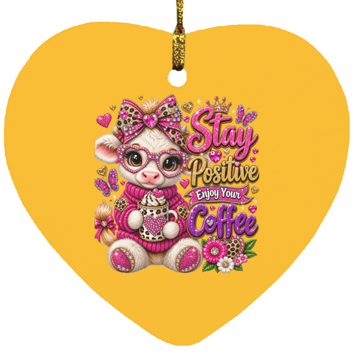 A heart-shaped ornament with an athletic gold hanging loop, featuring a cartoon pink-and-white cow wearing glasses and a bow, surrounded by flowers and the phrase 'Stay Positive Enjoy Your Coffee' in pink and purple lettering.