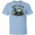 A light blue crewneck t-shirt featuring a 'Spooky Season' graphic on the chest with a hummingbird, flowers, and a gold heart.