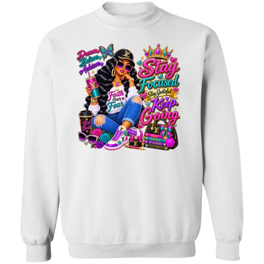 A white crewneck sweatshirt featuring a large, colorful graphic print on the front. The graphic depicts a woman in a black hat and sunglasses, holding a drink, surrounded by luxury-themed text like 'Stay Focused', 'Keep Going', and 'Dream Big Achieve', along with a Louis Vuitton monogram pattern.