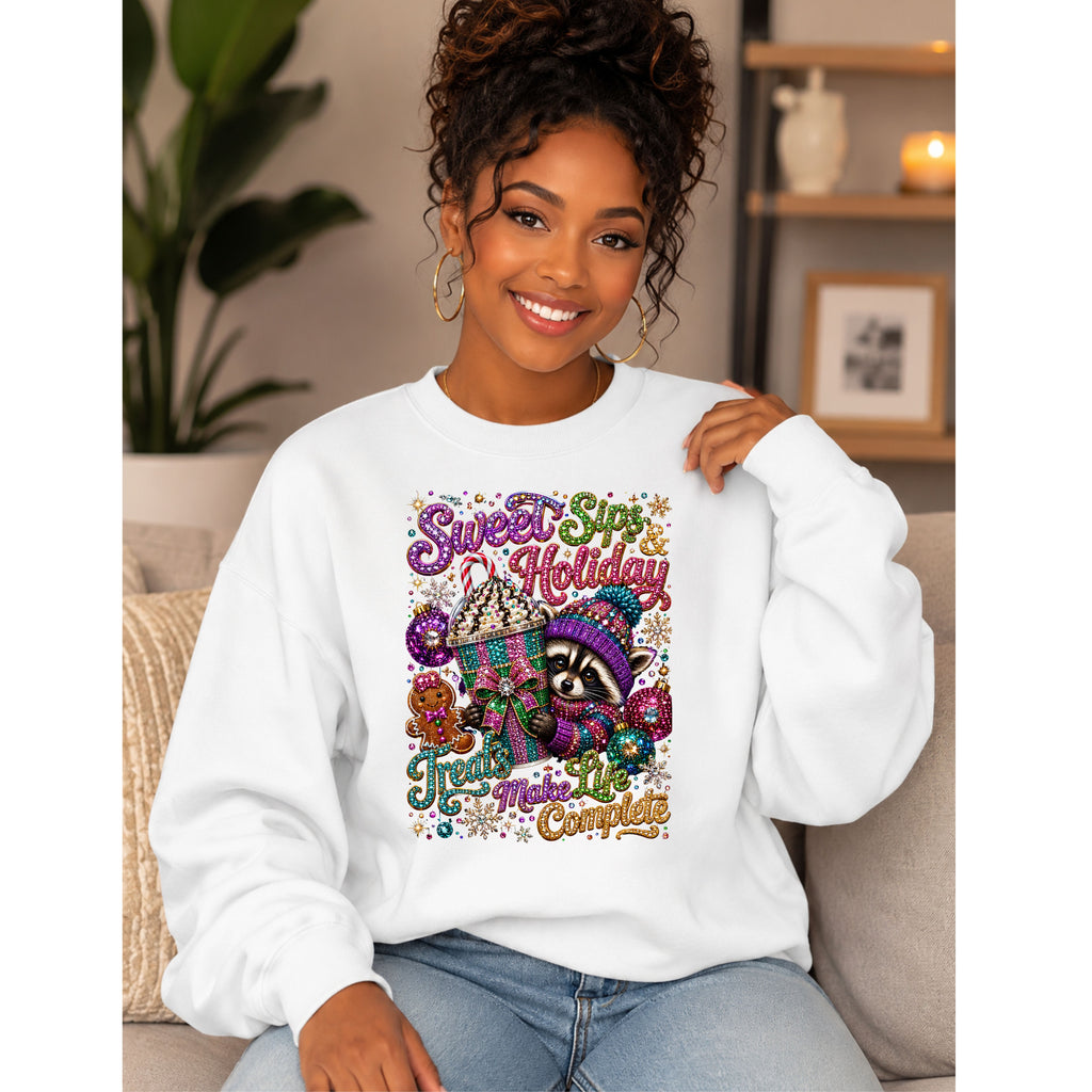 A woman wearing a white crewneck sweatshirt with a colorful 'Sweet Spot Holiday' raccoon graphic, sitting on a beige couch in a cozy living room setting.