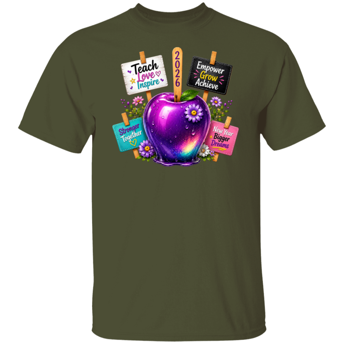 An olive green short-sleeve crewneck t-shirt featuring a colorful graphic of a purple and blue galaxy-adorned apple with flowers, surrounded by signs that read 'Teach Love Inspire', '2026', 'Empower Grow Achieve', 'Shine Together', and 'Have Bigger Dreams'.