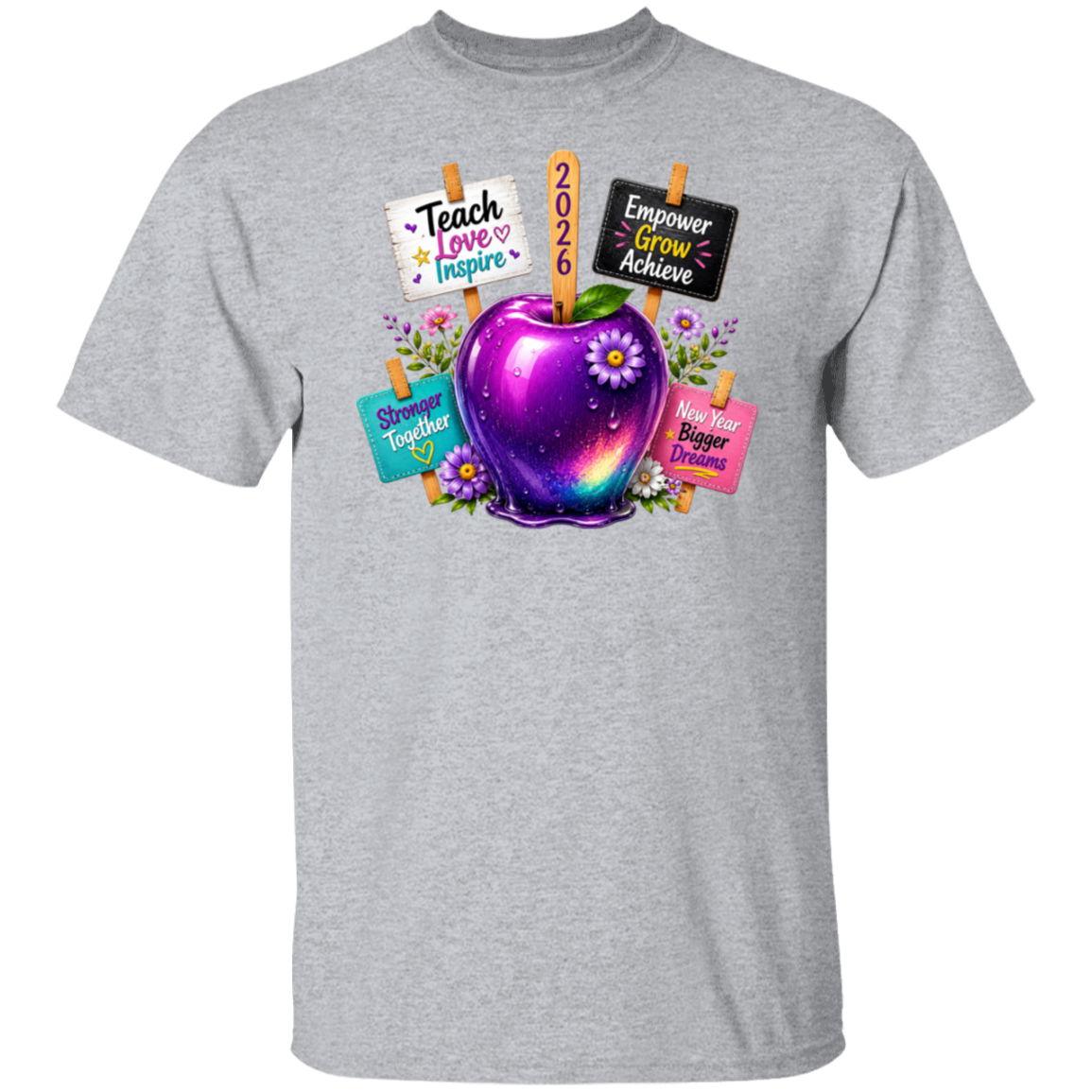 A heather gray short-sleeve crewneck t-shirt featuring a colorful graphic of a glowing purple galaxy apple with flowers, surrounded by signs that say 'Teach Love Inspire', '2026', 'Empower Grow Achieve', 'Shiny Together', and 'Hers Bigger Dream'.