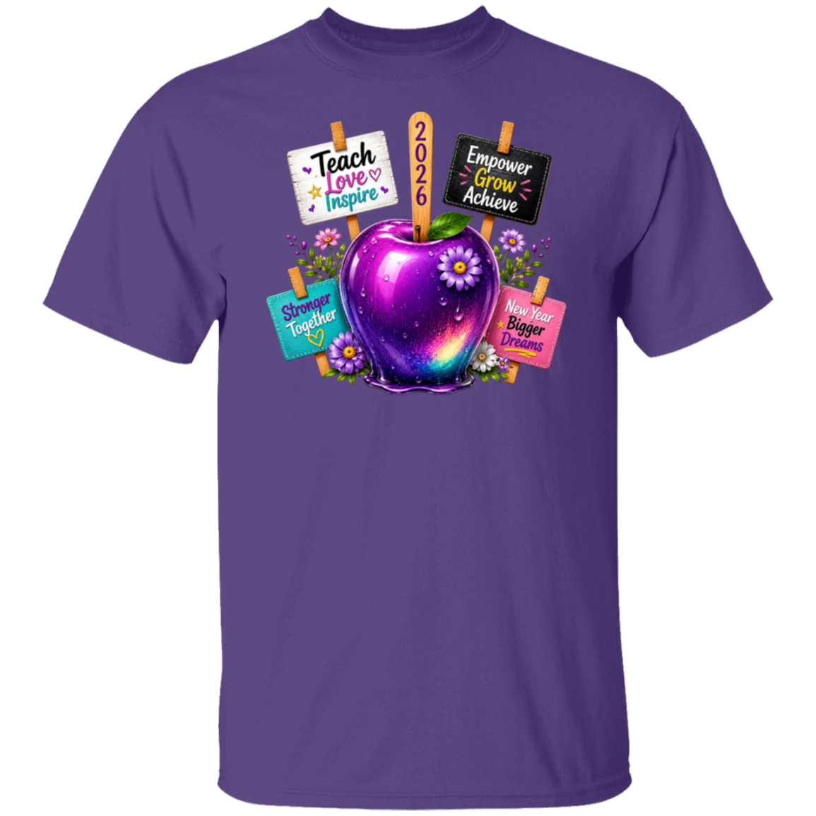 A purple short-sleeve crewneck t-shirt featuring a colorful graphic of a glowing purple apple with flowers, surrounded by signs that read 'Teach Love Inspire', '2026', 'Empower Grow Achieve', and 'Shine Together', on a plain white background.
