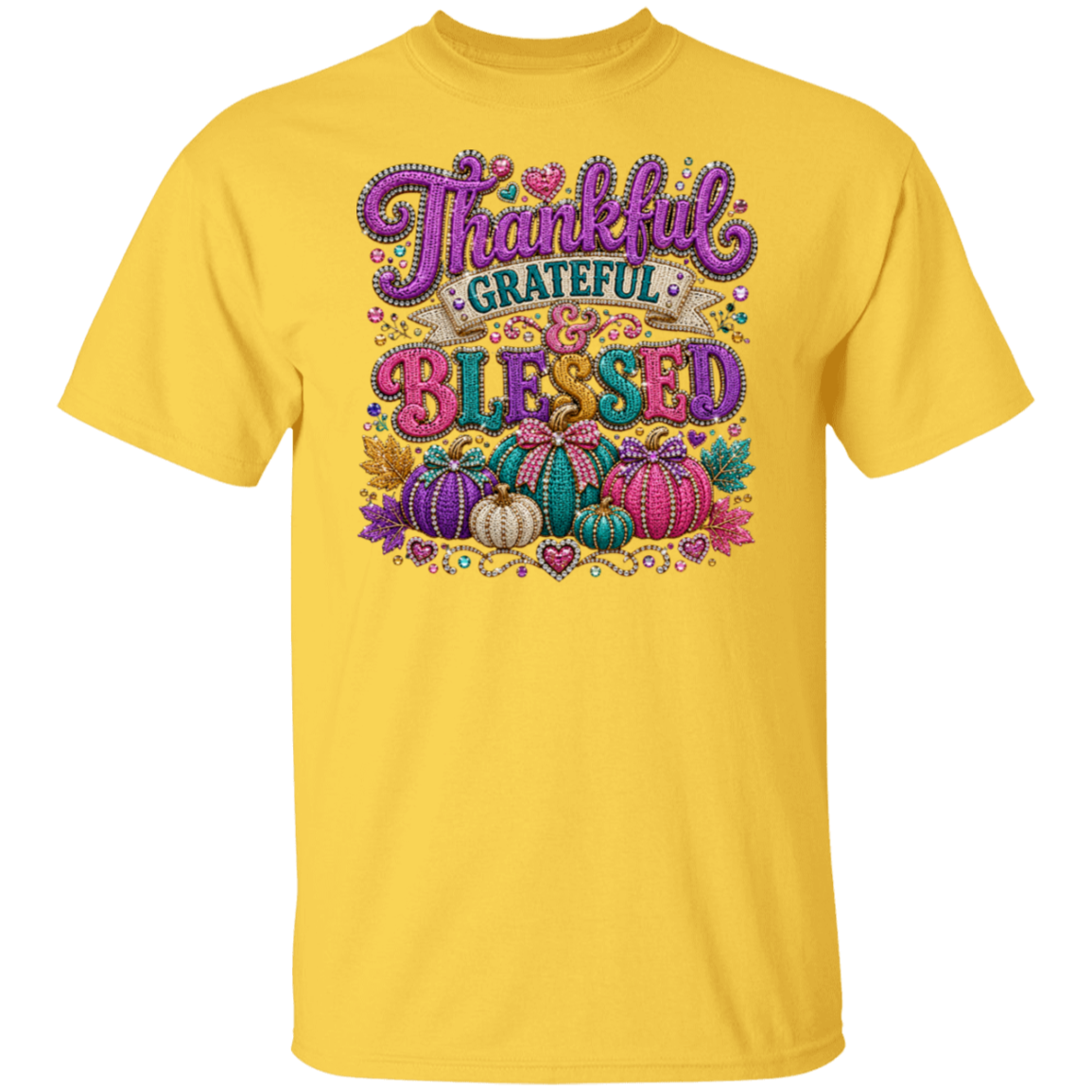 A daisy color short-sleeve crewneck t-shirt featuring a colorful graphic on the front with the words 'Thankful Grateful Blessed' in stylized purple and multicolor lettering, decorated with pumpkins and autumn leaves.