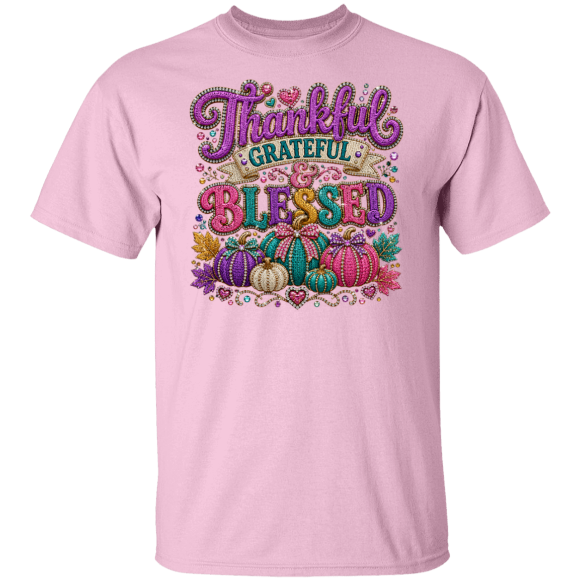 A light pink color short-sleeve crewneck t-shirt featuring a colorful graphic on the front with the words 'Thankful Grateful Blessed' in stylized lettering above a decorative autumn pumpkin illustration.