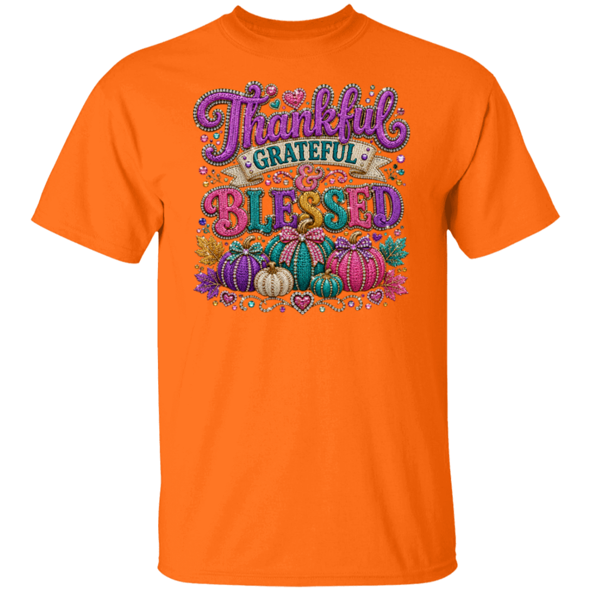 A safety orange color short-sleeve crewneck t-shirt featuring a colorful graphic on the front with the words 'Thankful Grateful Blessed' in stylized purple and multicolor lettering above a decorative pumpkin illustration. 