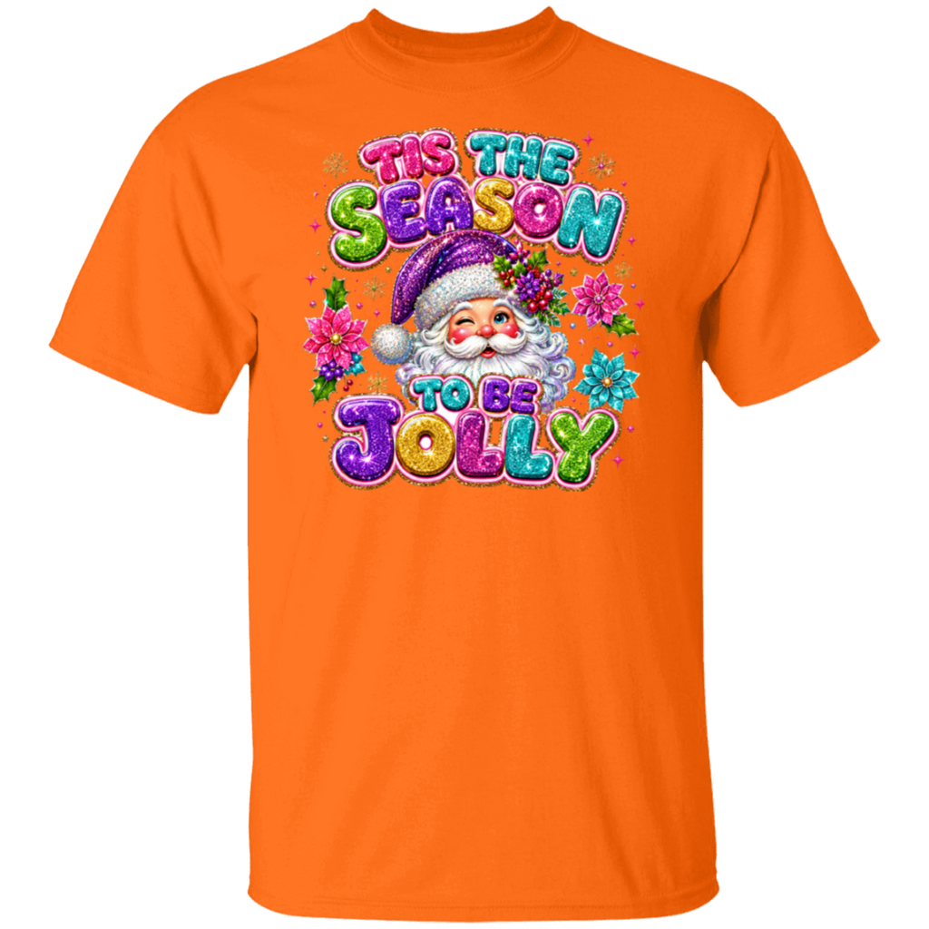An orange short-sleeve crewneck t-shirt featuring a colorful graphic of a Santa Claus character surrounded by flowers and the text 'TIS THE SEASON TO BE JOLLY' in a glittery, multi-colored font.