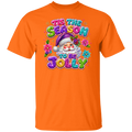 An orange short-sleeve crewneck t-shirt featuring a colorful graphic of a Santa Claus character surrounded by flowers and the text 'TIS THE SEASON TO BE JOLLY' in a glittery, multi-colored font.