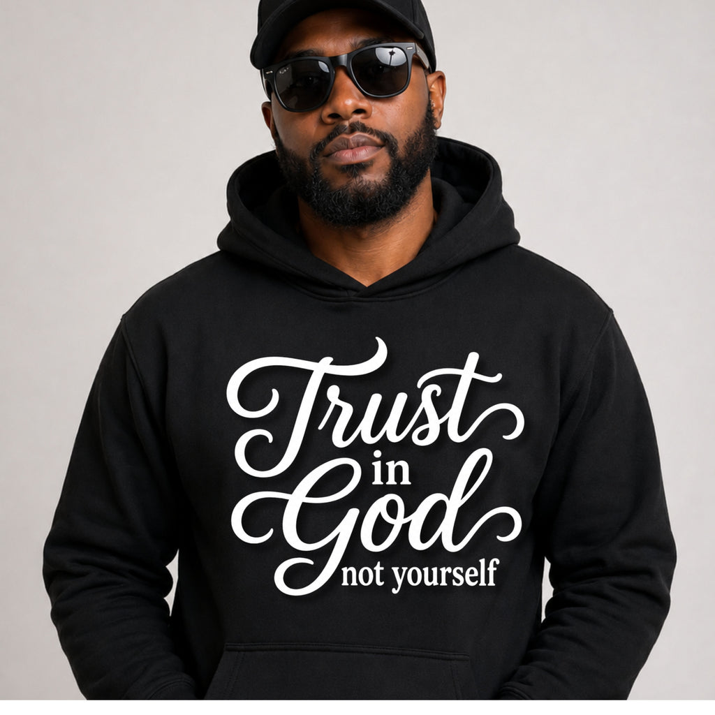A man wearing a black hoodie with the white text 'Trust in God not yourself' on the front, along with a black cap and sunglasses, against a plain light gray background.