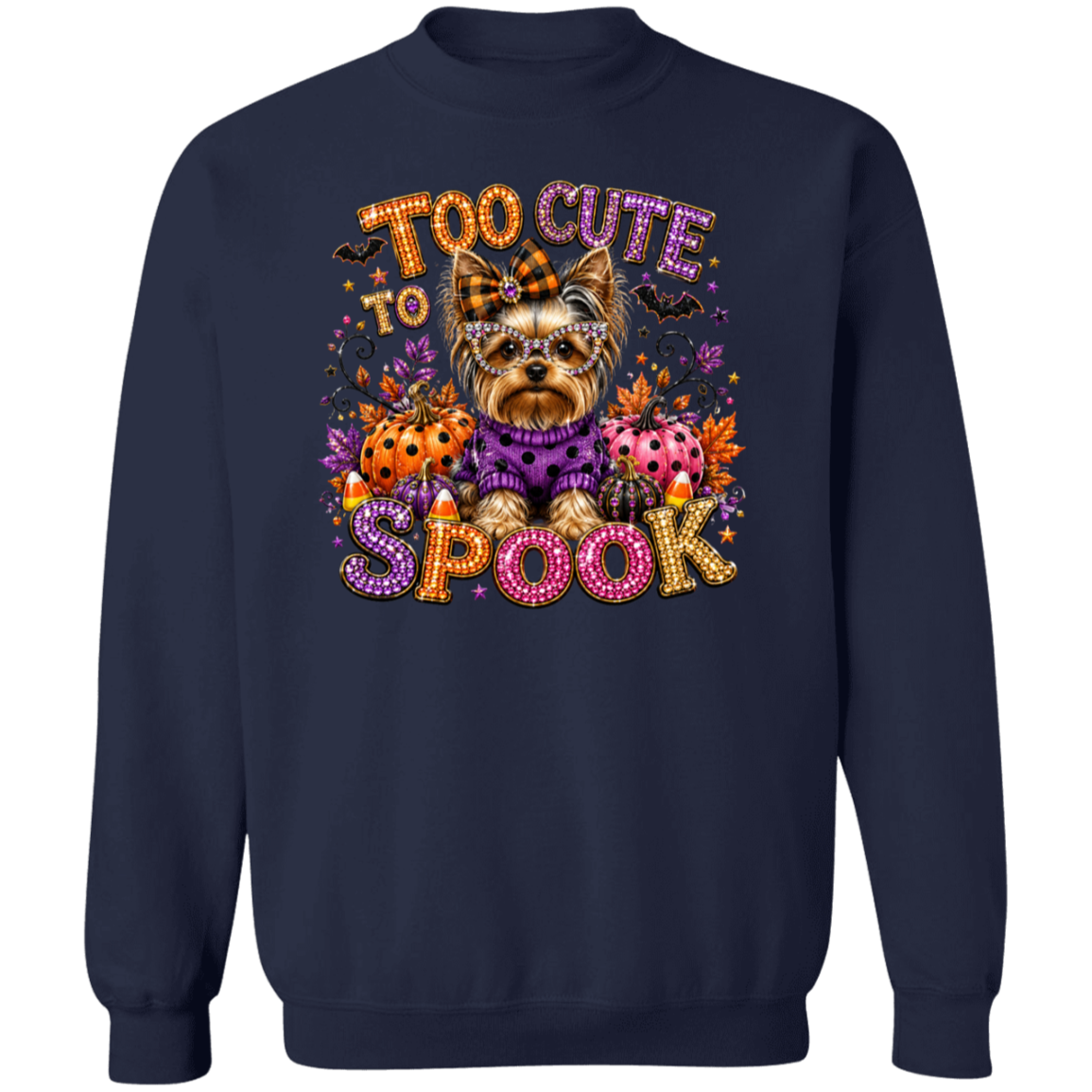 A navy blue crewneck sweatshirt featuring a colorful graphic of a small Yorkshire Terrier dressed in a purple sweater, surrounded by pumpkins, candy corn, spiders, and the text 'TOO CUTE TO SPOOK' in a glittery, multicolored font.
