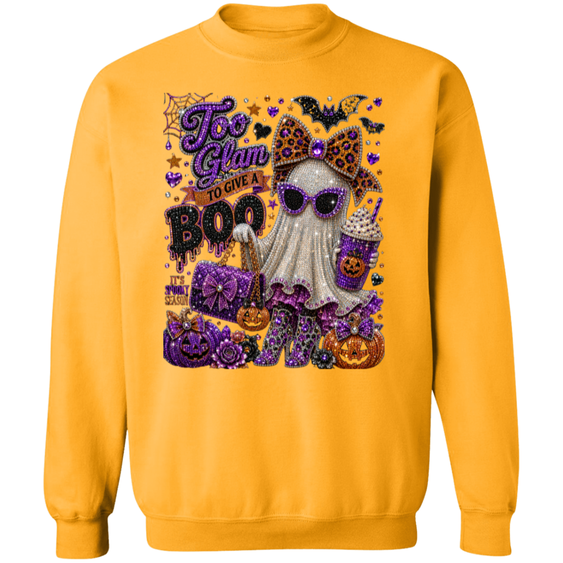 A gold crewneck sweatshirt featuring a large, detailed Halloween graphic on the front. The graphic includes a white ghost wearing leopard-print sunglasses and a purple bow, holding a drink, surrounded by pumpkins, a purple gift box, and the text 'Too Glam to Give a BOO'.