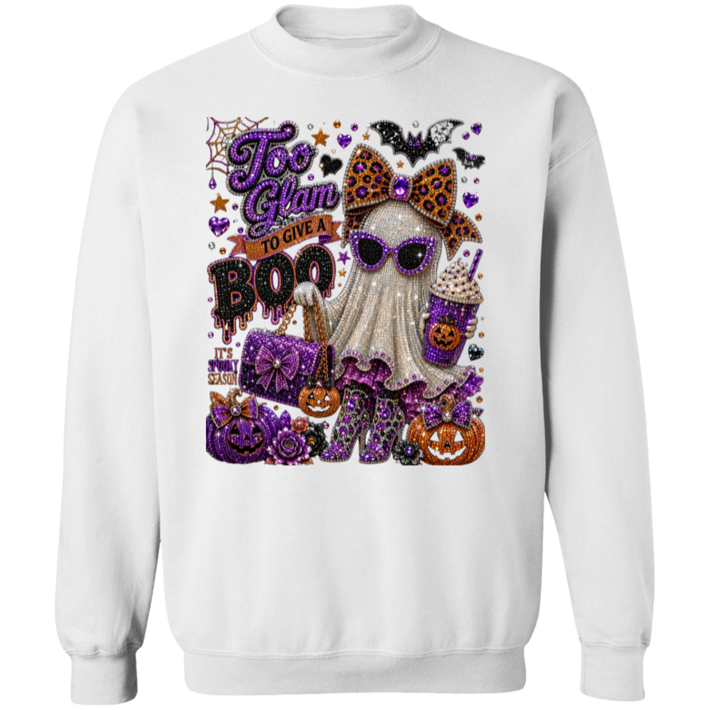 A white crewneck sweatshirt featuring a large, colorful glitter-style graphic on the front with a ghost, pumpkins, bats, and the text 'Too Glam to Give a BOO'.