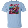 A light blue crewneck t-shirt featuring a colorful graphic print of a cow wearing sunglasses and a hat with the text 'Too Glam to give a Damn!'.